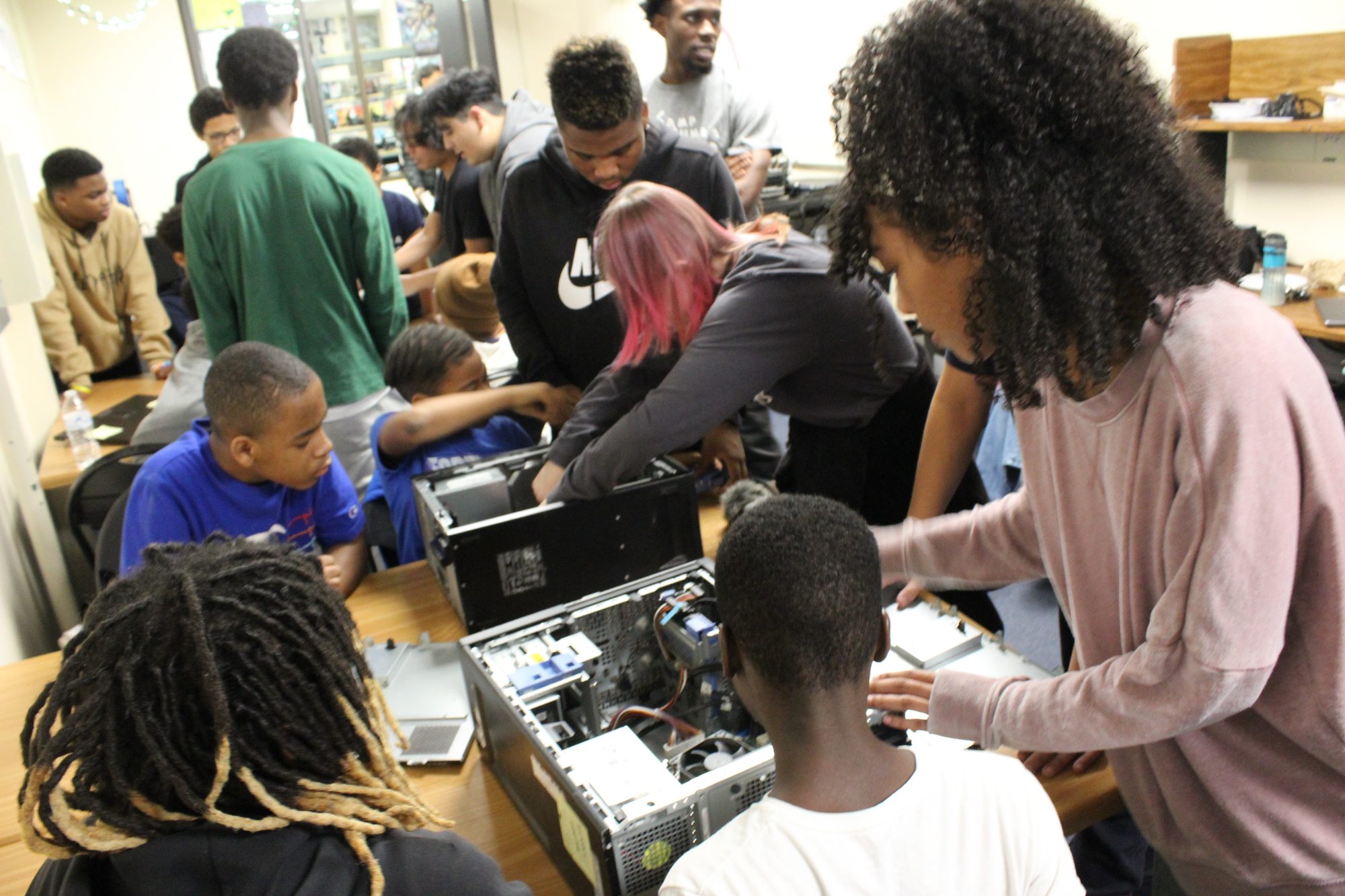 A crowded YTC clubroom at ETHS — older students showing younger students the inside of a computer
