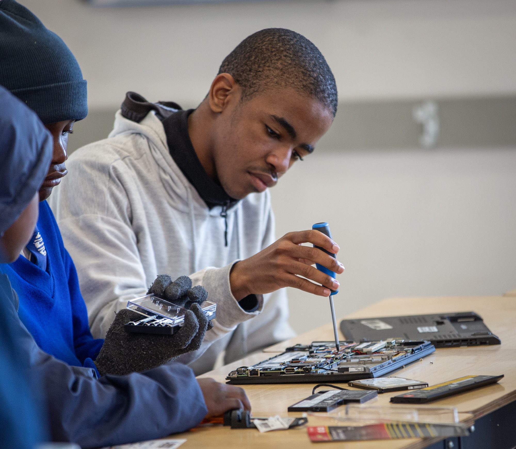A student repairing an open computer during the Namibia program